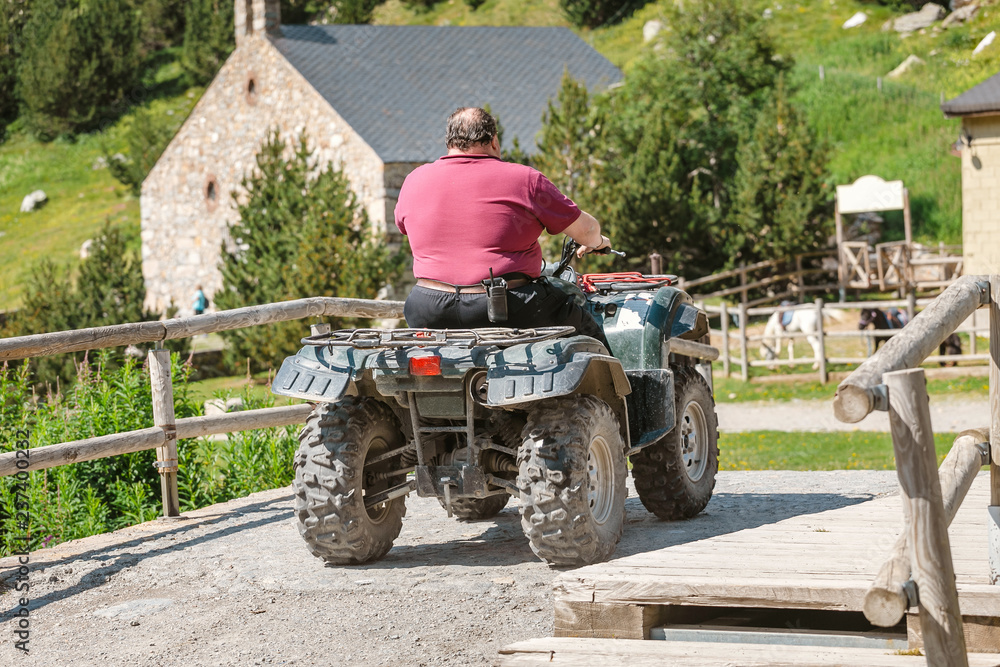 Fototapeta premium Fat Man on the Quad Bike in mountain village