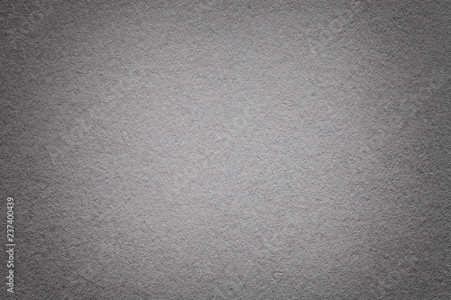 Texture of old dark gray paper background, closeup. Structure of dense cardboard.