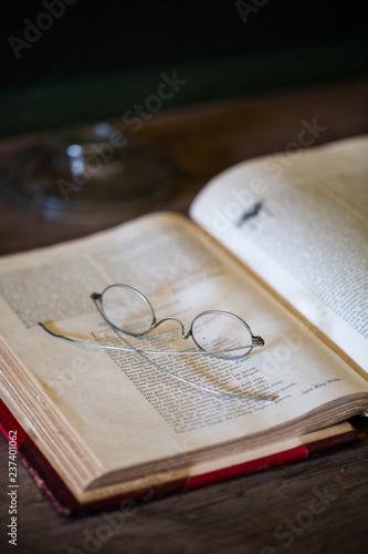 Old book with antique glassesl photo