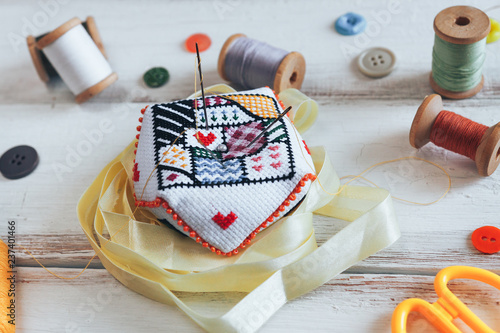 Canvas Print Handmade pin cushion with simple ornament and needles on the white desk