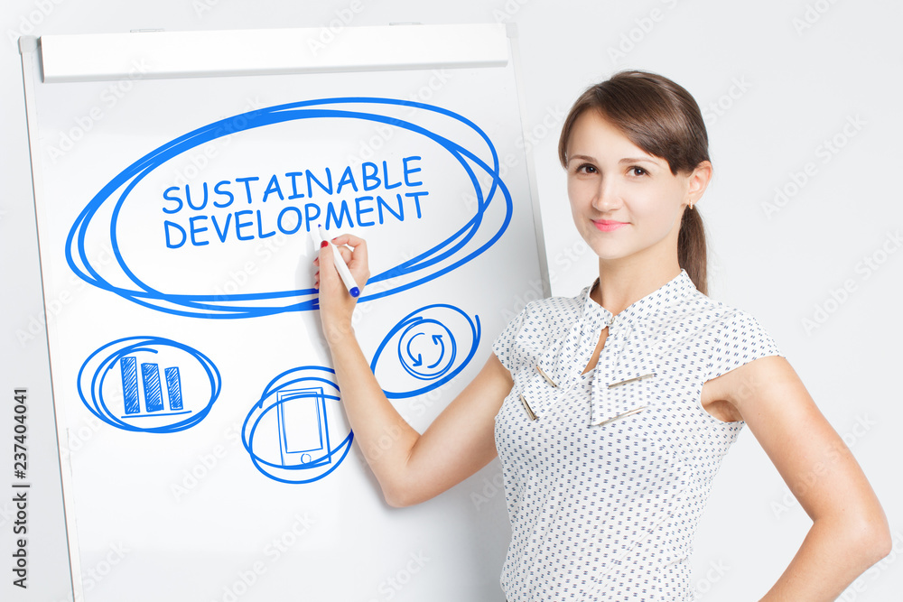 Business, Technology, Internet and network concept. A young entrepreneur writes on the blackboard the word: Sustainable development Business, Technology, Internet and network concept. A young entrepreneur writes on the blackboard the word: Sustainable development