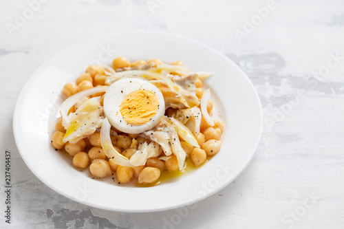 chick-pea with cod fish and boiled egg on white plate