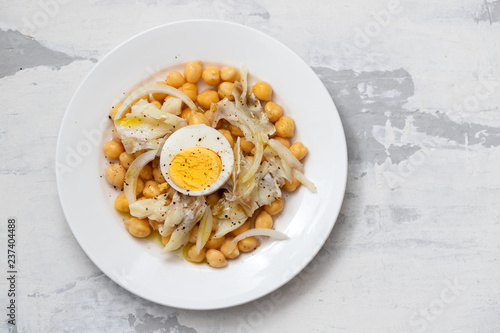 chick-pea with cod fish and boiled egg on white plate