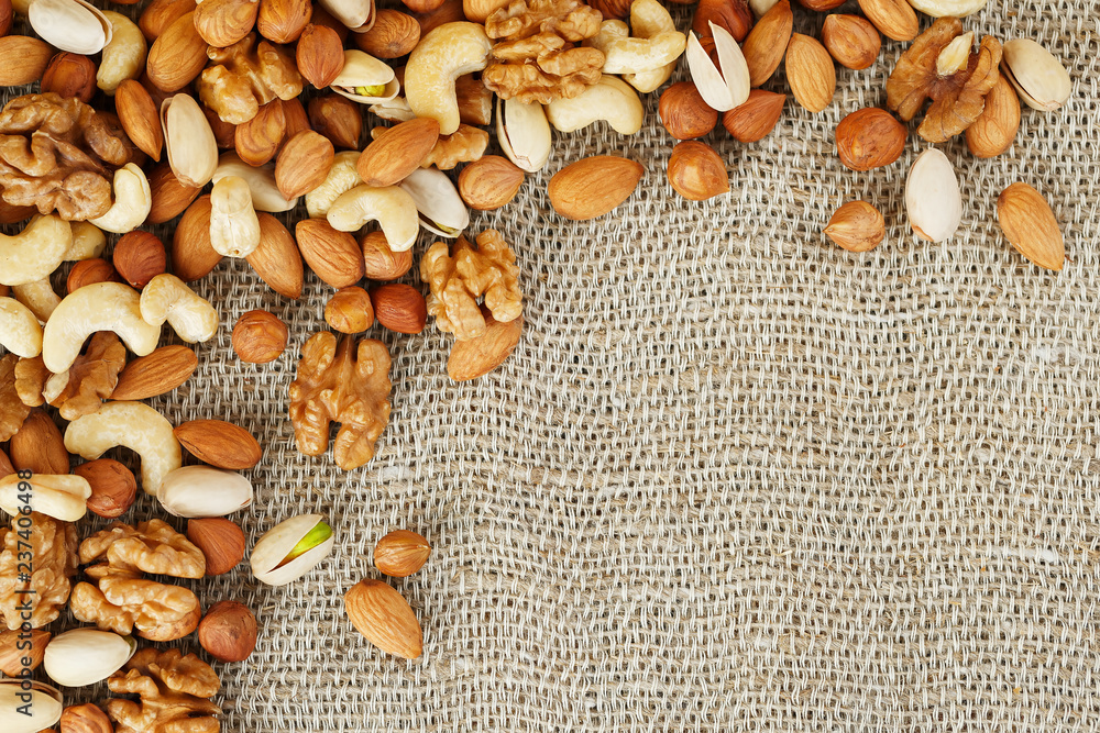 Mix of nuts lying on a background of brown cloth burlap. Mix of nuts lying on a background of brown cloth burlap.