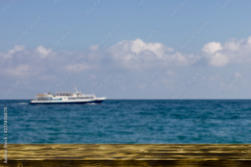 wooden table on the beach by the sea and a sailing ship