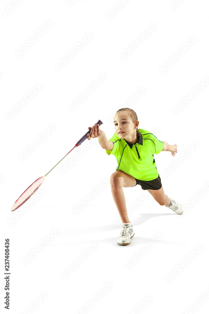 The one caucasian young teenager girl playing badminton at studio. The female teen player isolated on white background in motion The one caucasian young teenager girl playing badminton at studio. The female teen player isolated on white background in motion