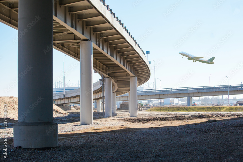 Airplane flies over a large automobile bridge Airplane flies over a large automobile bridge