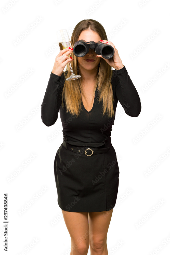Woman with champagne celebrating new year 2019 and looking for something in the distance with binoculars on isolated white background Woman with champagne celebrating new year 2019 and looking for something in the distance with binoculars on isolated white background