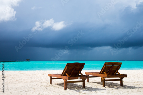 tropical beach in Maldives with few palm trees and blue lagoon