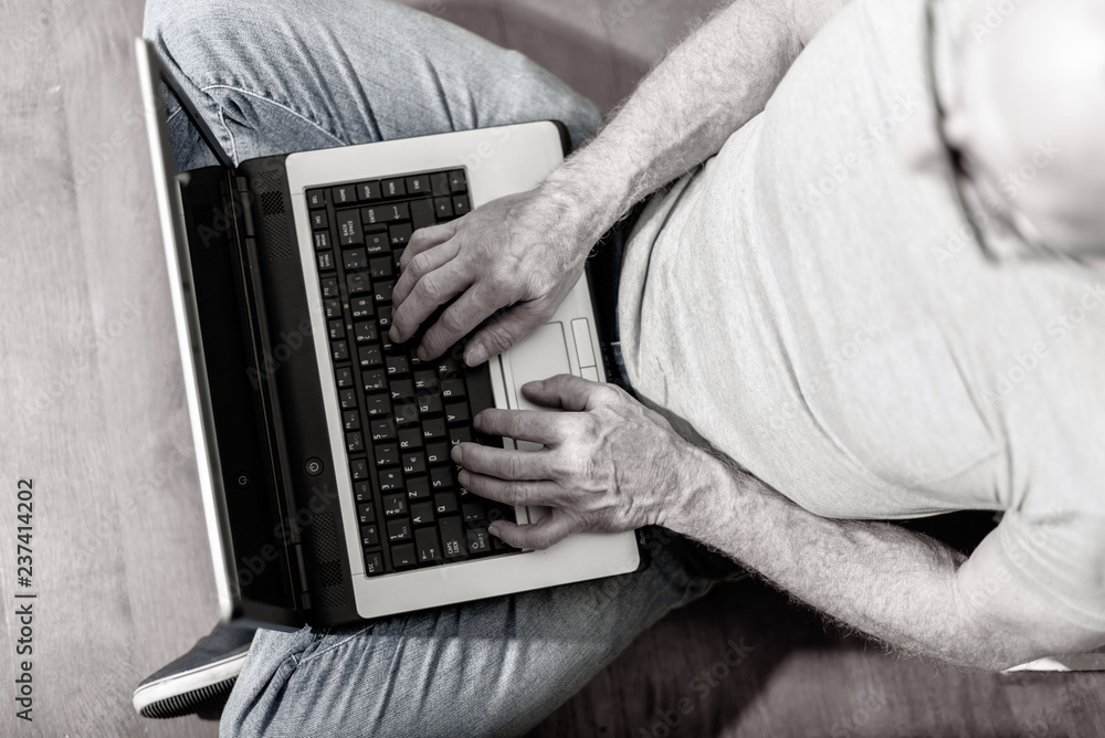 Naklejka premium Top view of man working on his laptop