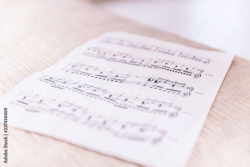 Fototapeta premium Closeup sheet with musical notes lying on the bed