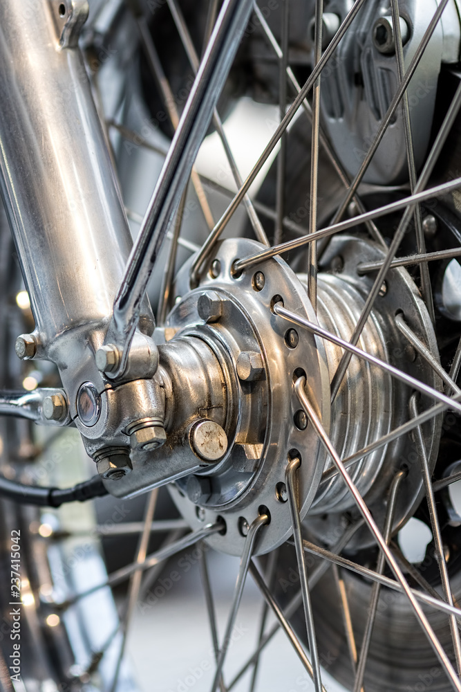 Obraz premium Engineered motorcycle wheel parts. Disc brake suspension and spokes. Complex engineering close-up.