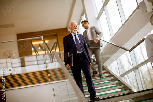 Busenessmen coming down the stairs in office