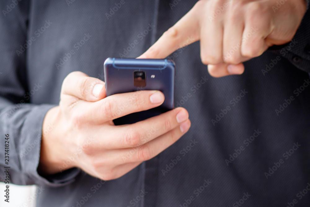 Man using mobile smartphone - focus on top of the phone Man using mobile smartphone - focus on top of the phone