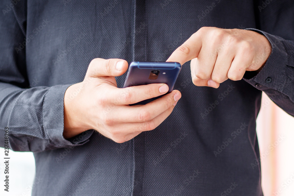 Man using mobile smartphone - focus on top of the phone Man using mobile smartphone - focus on top of the phone