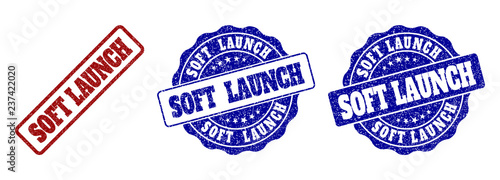 SOFT LAUNCH scratched stamp seals in red and blue colors. Vector SOFT LAUNCH labels with scratced style. Graphic elements are rounded rectangles, rosettes, circles and text labels.