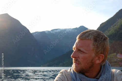 Blonde adult man in oudoors, sunset with copy space, sun from the side