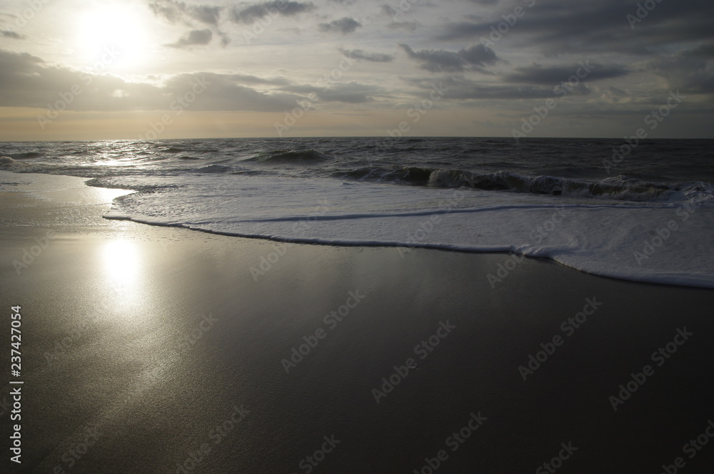 Fototapeta premium Spiegelnder Nordseestrand bei Sonnenuntergang