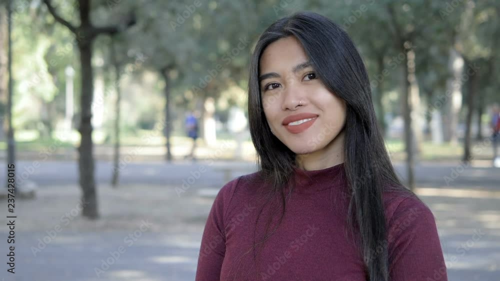 Asian attractive woman sending kisses to teh camera in the park-slow motion Asian attractive woman sending kisses to teh camera in the park-slow motion