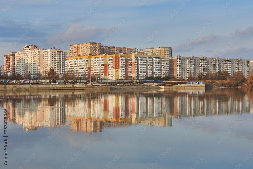 Microdistrict in the West of Krasnodar and its reflection in the Kuban River at sunset. Two worlds in one place.
