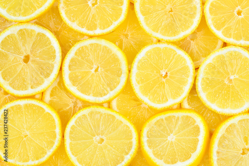 A slices of fresh juicy yellow lemons. Texture background, pattern.