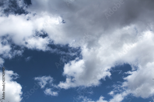 white clouds in the blue sky and among the clouds unidentified flying object, background image