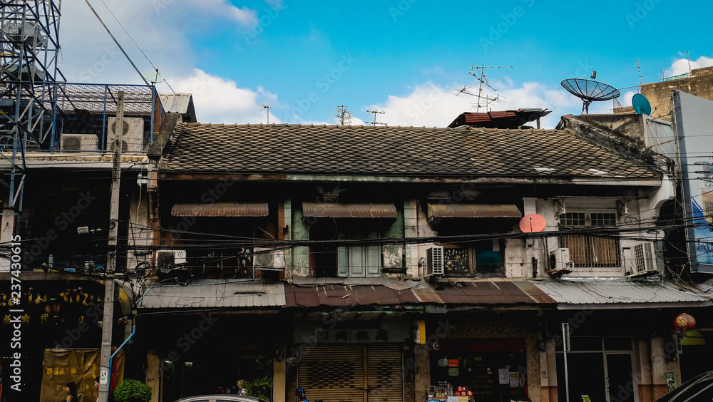 Old poor rusty house in Bangkok with clear blue sky