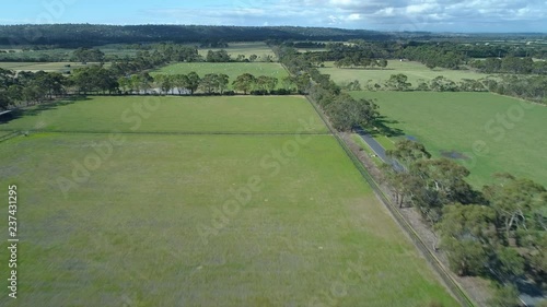 Forward flight over agricultural fields and pastures on sunny day