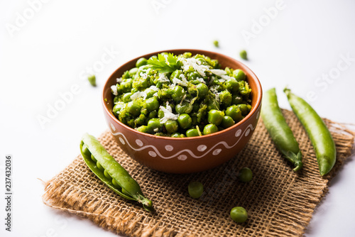 Green peas dry recipe or matar ki sookhi sabji, served in a serving pan or terracotta bowl. Selective focus photo