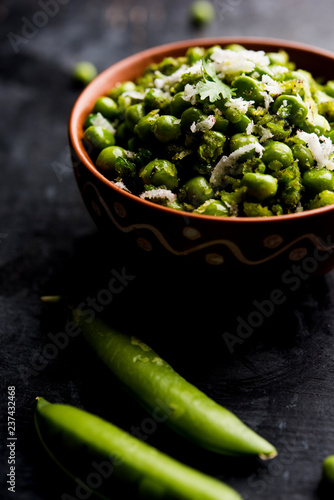 Green peas dry recipe or matar ki sookhi sabji, served in a serving pan or terracotta bowl. Selective focus photo