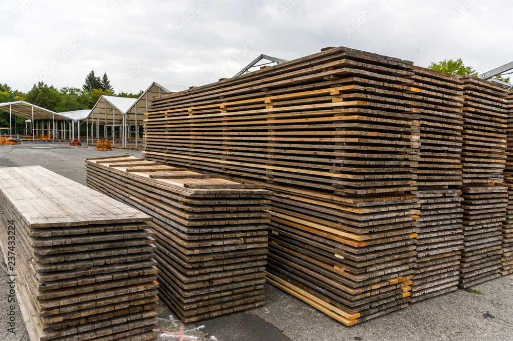 Messebau einer Regionalmesse, Zeltaufbau, Holzpfosten und Holzbretter für Zeltboden auf dem Stapel, im Hintergrund Zelte im Aufbau, Aluminiumprofile und weitere Elemente Messebau einer Regionalmesse, Zeltaufbau, Holzpfosten und Holzbretter für Zeltboden auf dem Stapel, im Hintergrund Zelte im Aufbau, Aluminiumprofile und weitere Elemente