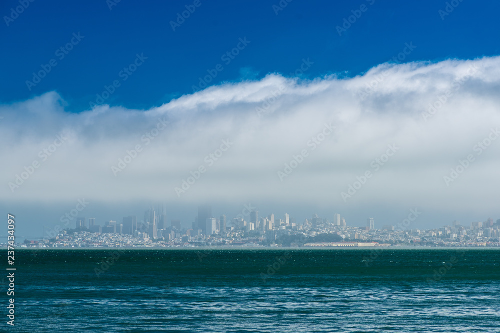 the city of San Francisco sits beneath a layer of fog