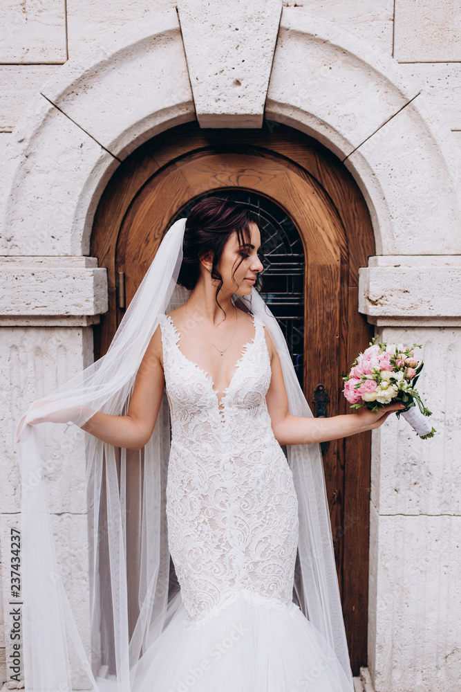 Bride in a white dress. Bride with a bouquet at the door of the castle. Bride in a white dress. Bride with a bouquet at the door of the castle.