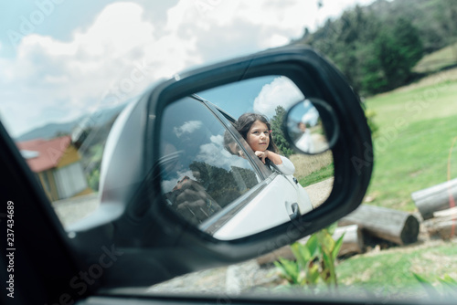 Hispanic girl looking through the window of a car photo