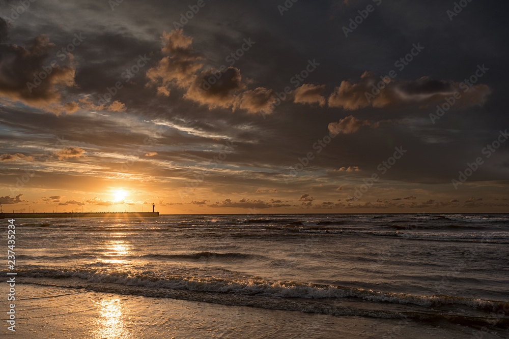 Sunset in Leba sun, mole and lighthouse, Poland Sunset in Leba sun, mole and lighthouse, Poland