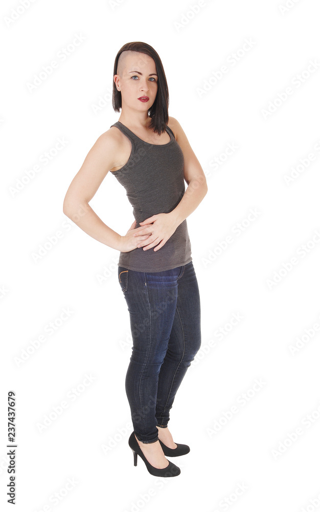 A gorgeous woman standing in profile in jeans A gorgeous woman standing in profile in jeans