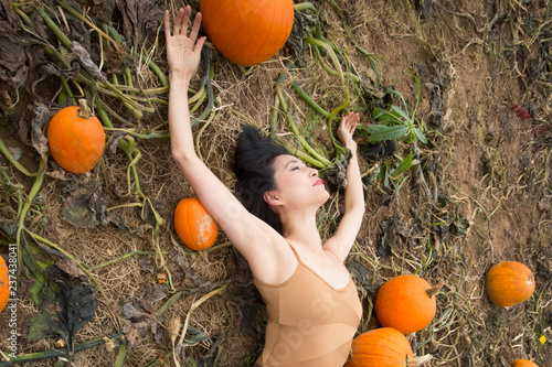 Adult woman dancing in a Connecticut pumpkin patch in autumn. photo