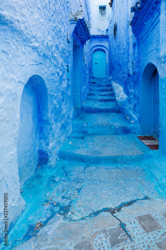 little blue street with doors and walls in blue city in Morocco © sergejson