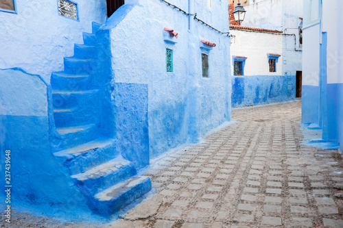 blue walls and stairs on the street in blue city Chefchaouen in Morocco © sergejson