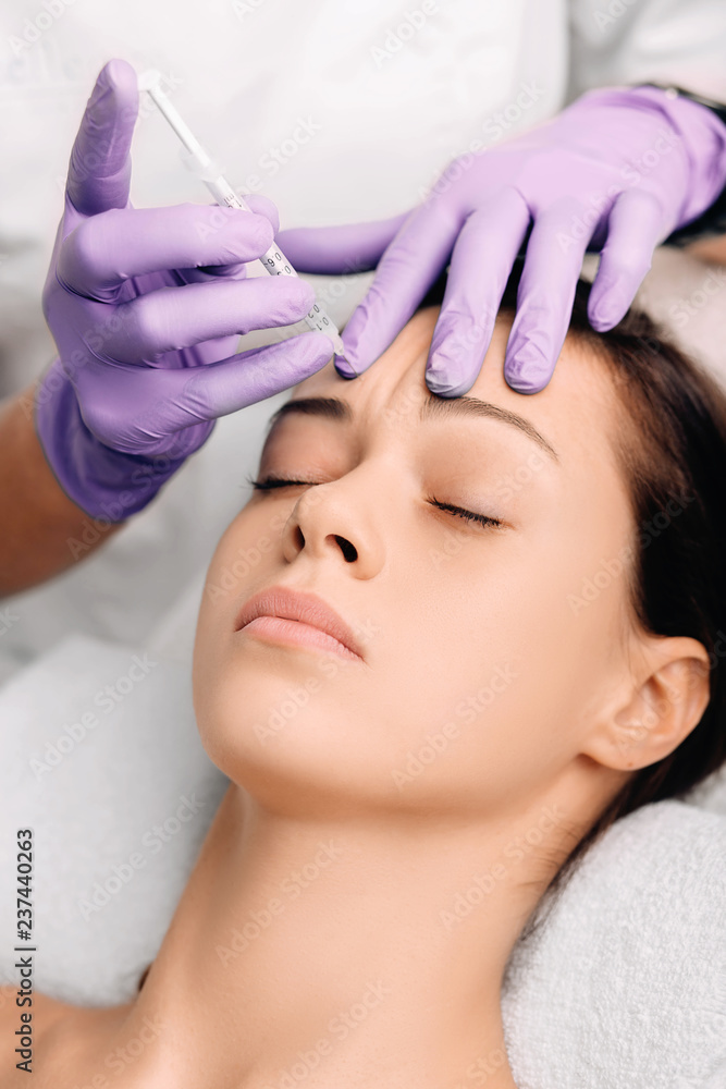 doctor applying facial injections for facelift on forehead