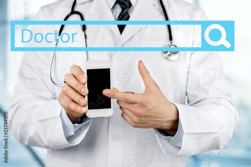 Close-up of male Doctor pointing at smartphone