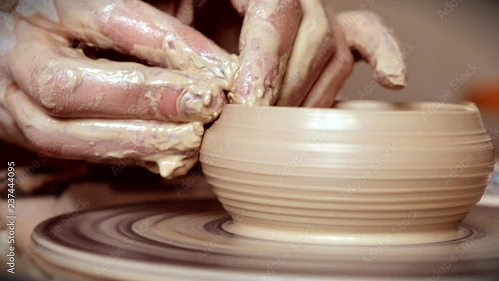 Woman girl her hands dub wall jug, sculpts out of clay on circle.Workshop on sculpt white clay closeup.Dirty hands in the clay.Making ceramic products Macro. Artistic creative. Camera motion. Woman girl her hands dub wall jug, sculpts out of clay on circle.Workshop on sculpt white clay closeup.Dirty hands in the clay.Making ceramic products Macro. Artistic creative. Camera motion.
