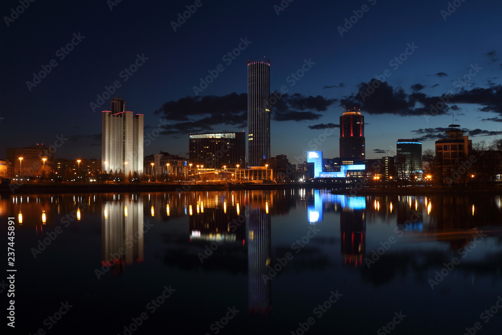 View over night modern city with skyscrapers by the river