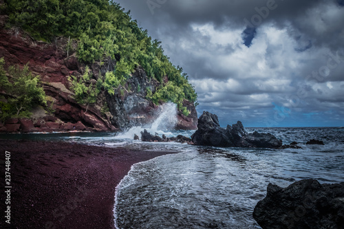 Red sand  mountain crashing waves and stormy sky