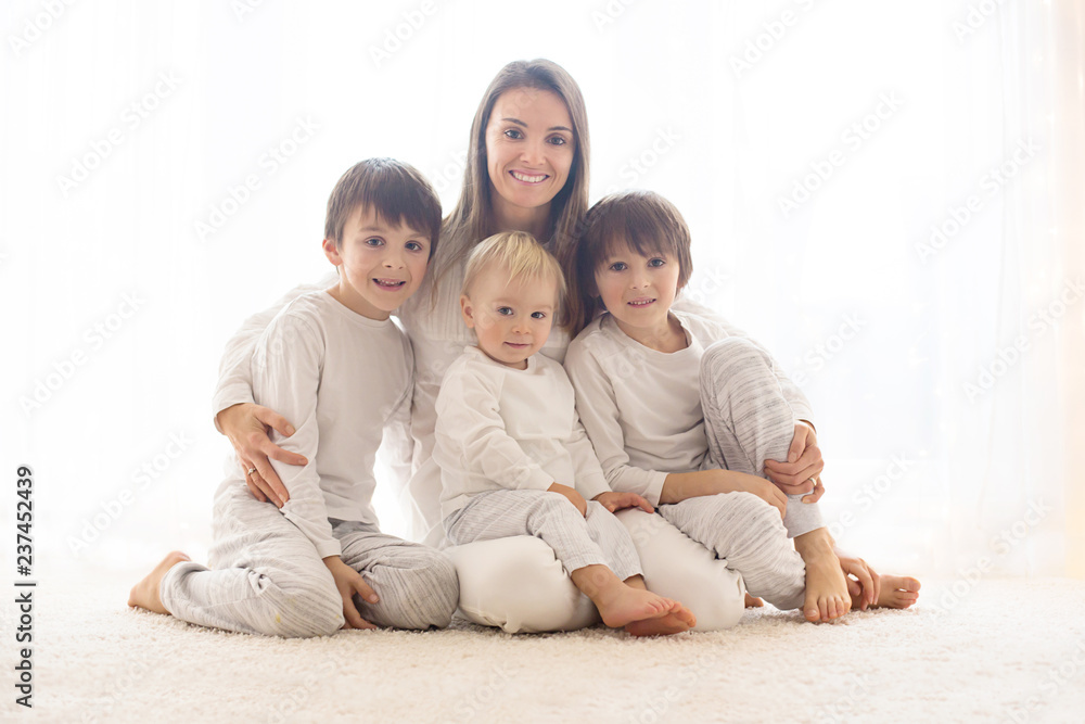 Family portrait of mother and her three boys, isolated on white, back light Family portrait of mother and her three boys, isolated on white, back light