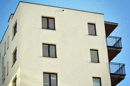 Modern apartment buildings on a sunny day with a blue sky. Facade of a modern apartment building © Grand Warszawski