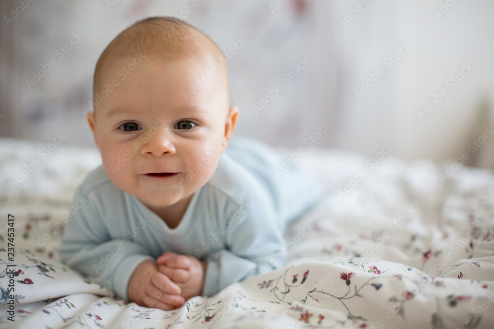 Adorable baby boy in white sunny bedroom in winter morning Adorable baby boy in white sunny bedroom in winter morning