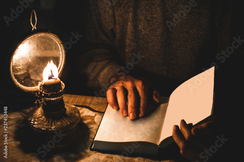 male holding book and oil lamp is near