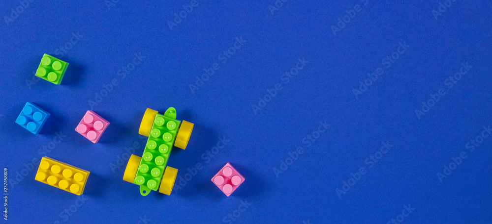 Obraz premium Colorful plastic toy car building blocks on blue background