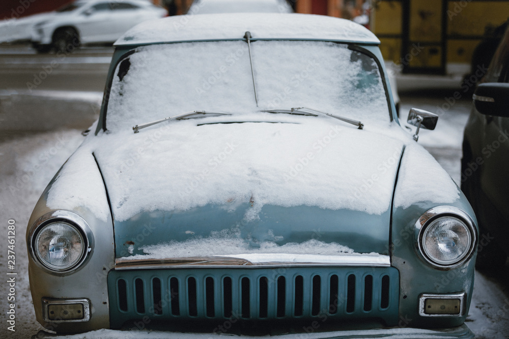 old car in the snow. winter in the city